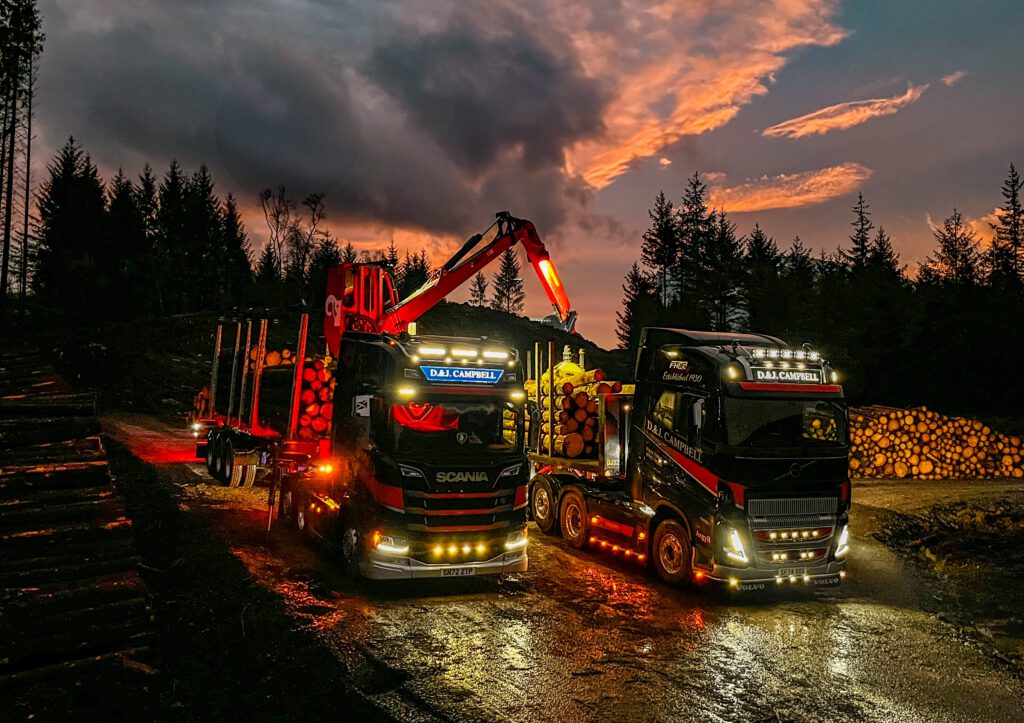 D&J Campbell haulage contractors’ Scania and Volvo timber lorries at dusk